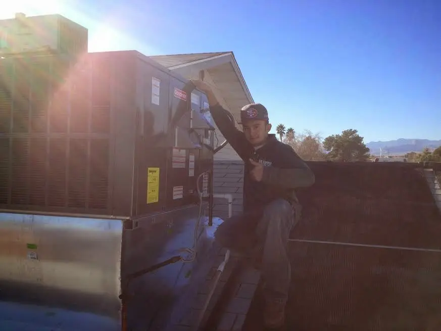 HVAC technician performing HVAC Inspection on a rooftop unit in Wilson